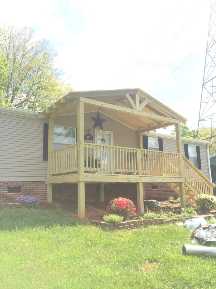 New gabled porch roof and deck railing added to a ranch home in Vinton